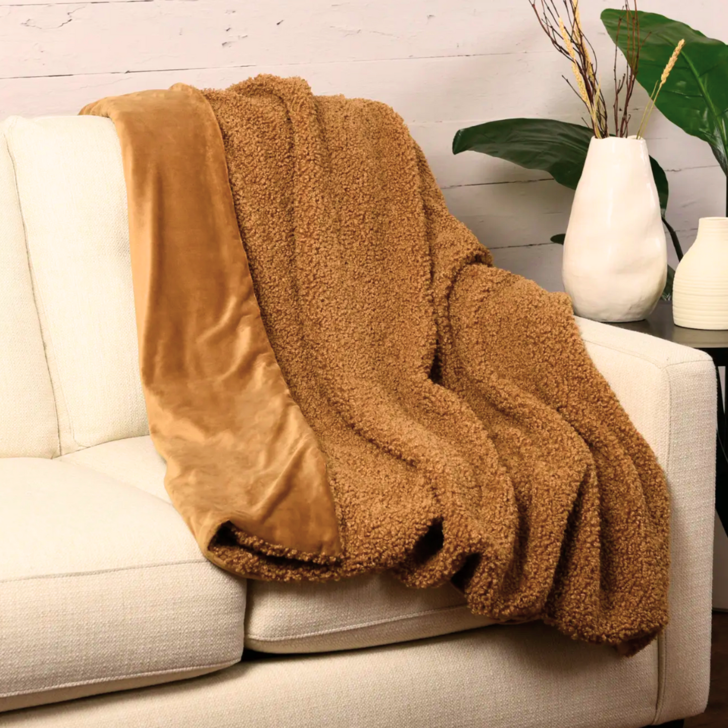 Luxurious brown plush throw with a soft velvet lining draped across a beige sofa.