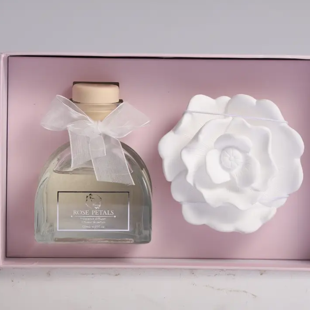 Glass diffuser bottle and ceramic diffuser flower nestled in gift box packaging. 
